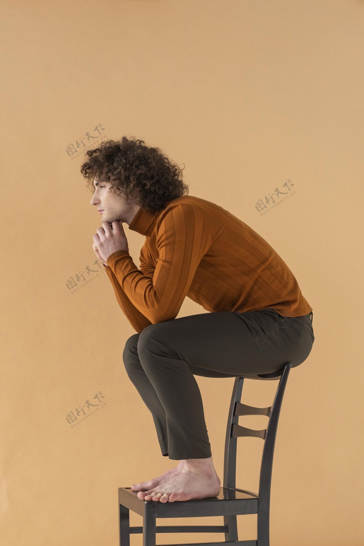 男人卷发男人穿着棕色衬衫在椅子上摆姿势模特帅哥时尚