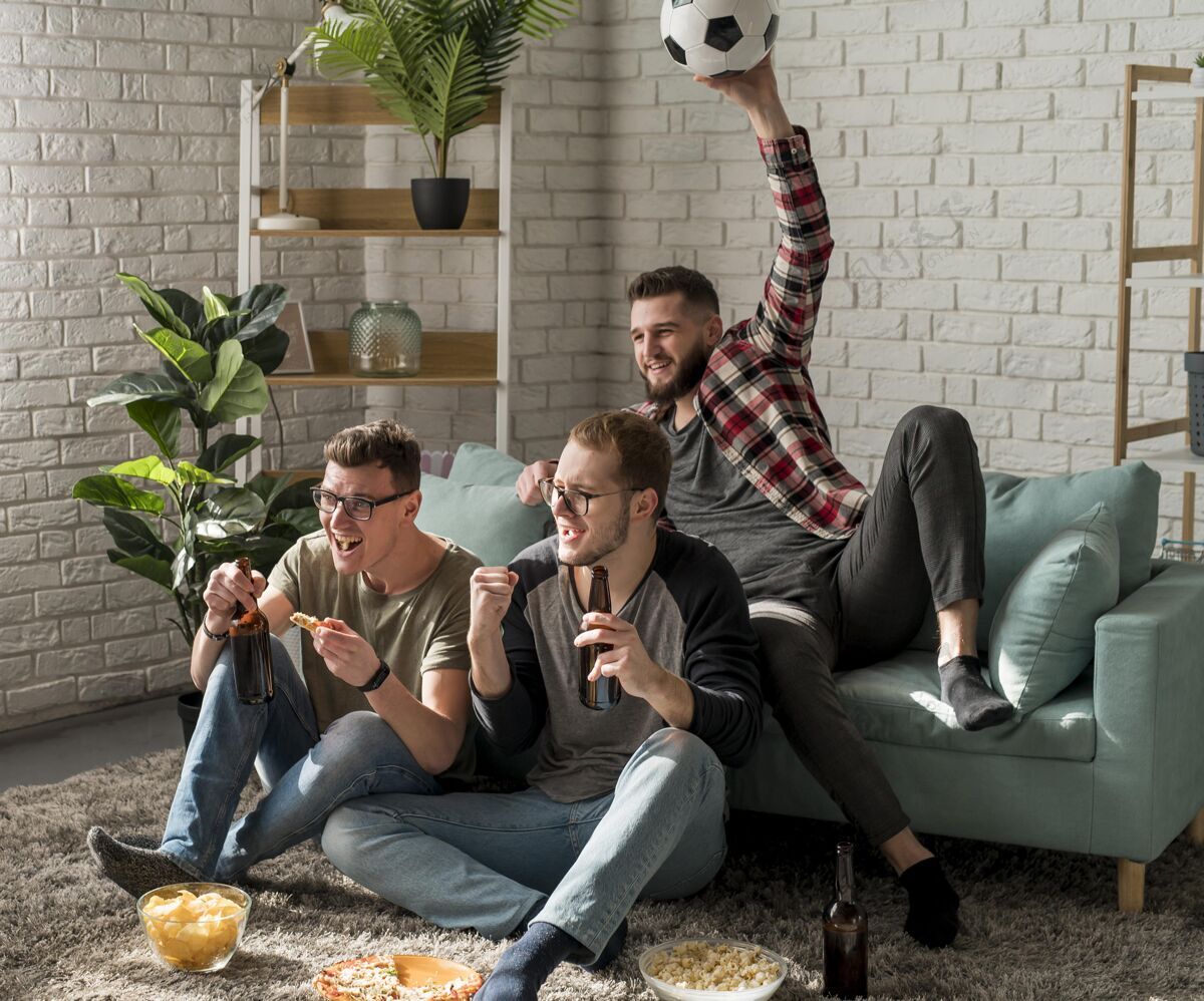 比萨饼男性朋友在电视上看体育节目 边吃零食边喝啤酒看看电视男