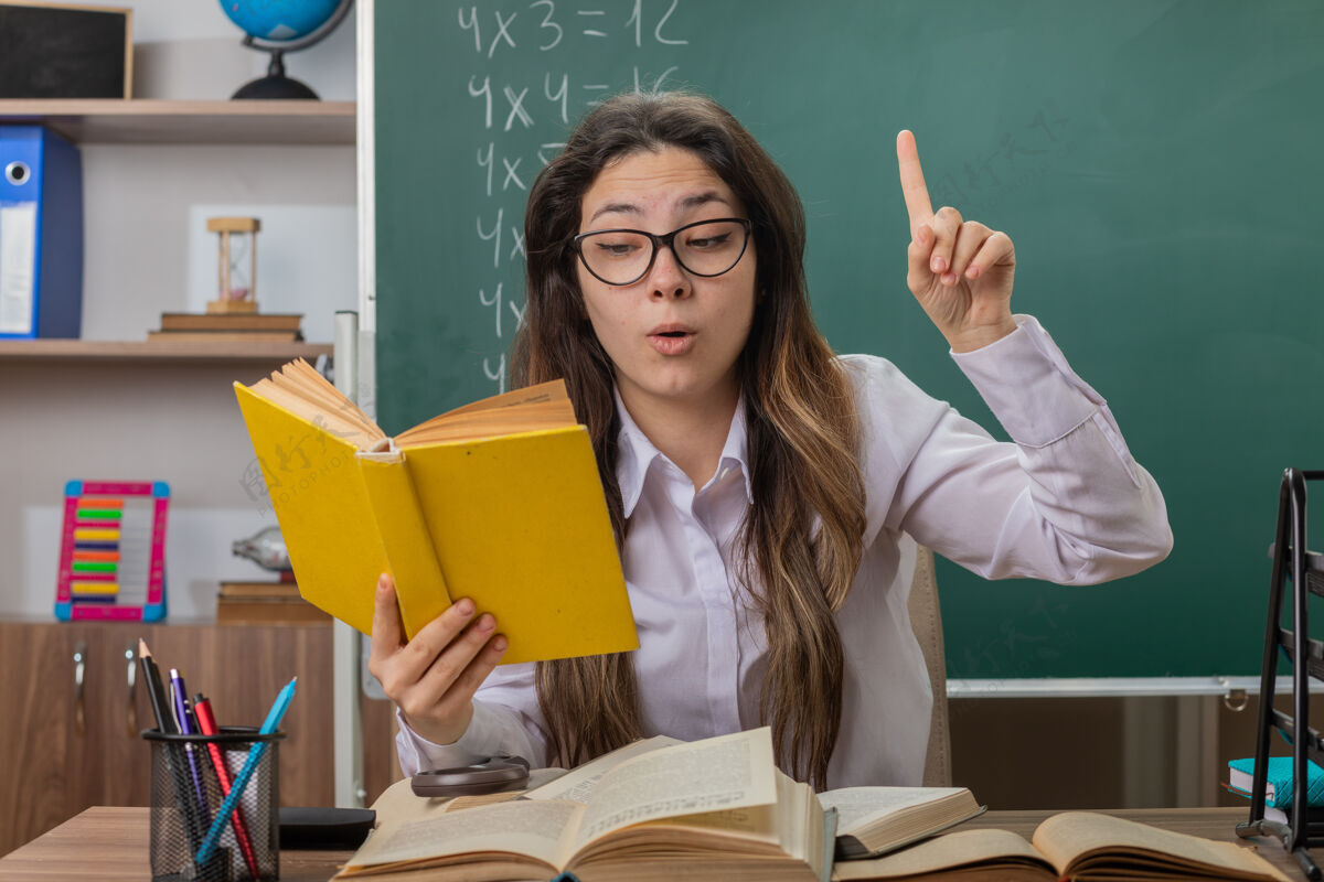 手指年轻的女老师戴着眼镜看书 看起来很好奇目录眼镜学校