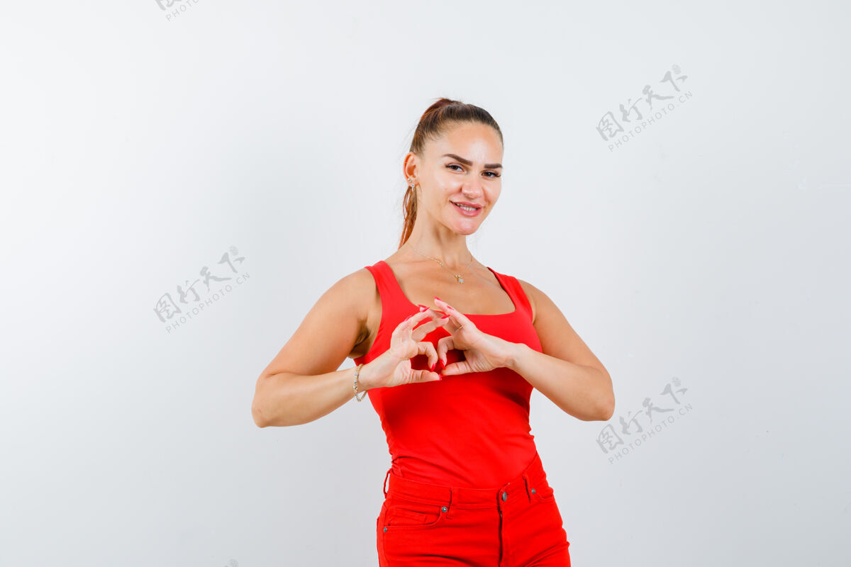 皮肤身着红色单品 红色长裤 展现心形的年轻女士 看起来很漂亮正面图护理娇生惯养健康