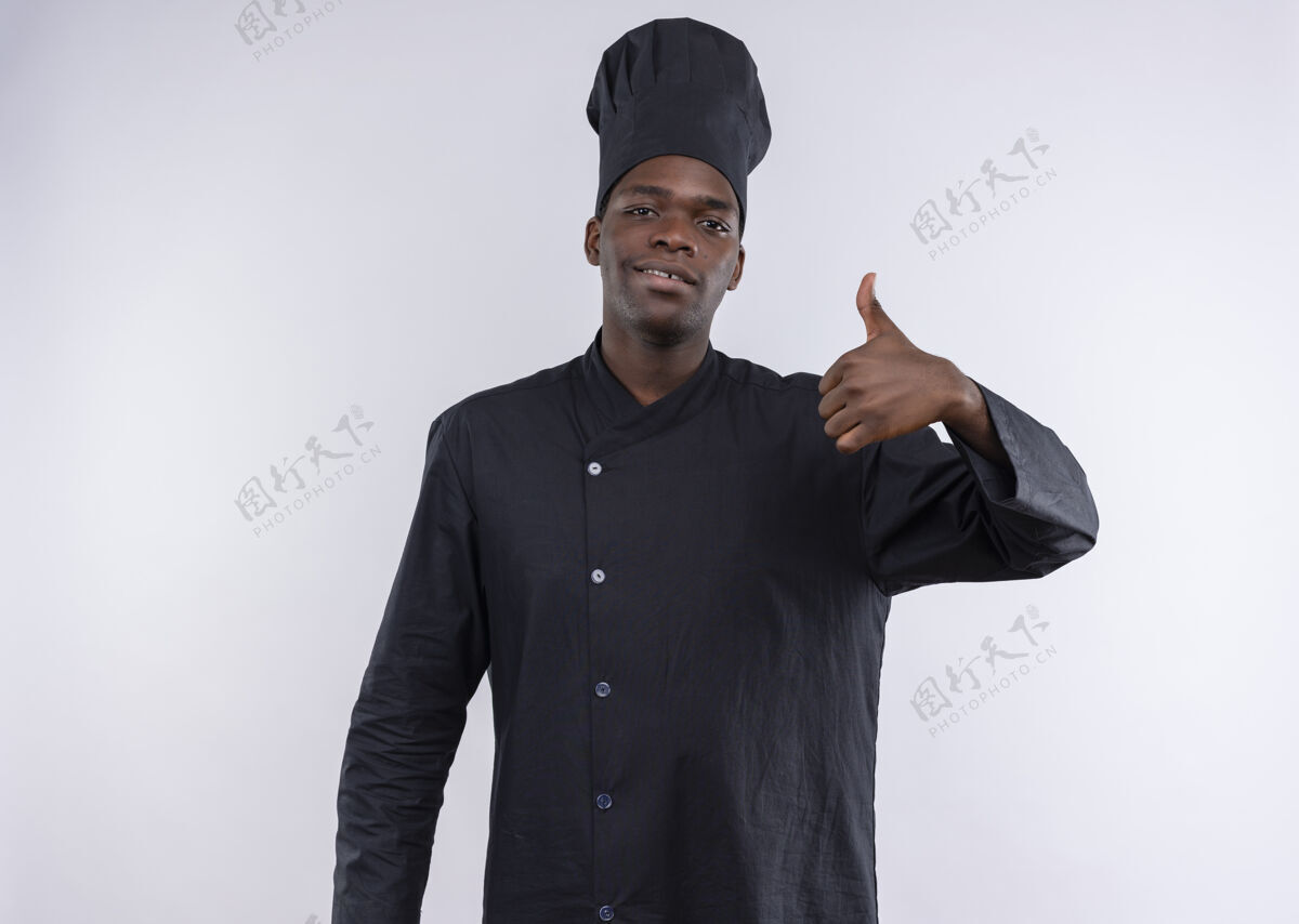 信心年轻自信的美国黑人厨师身着厨师制服 竖起大拇指 看着白色的相机 留着复印空间复制大拇指烹饪
