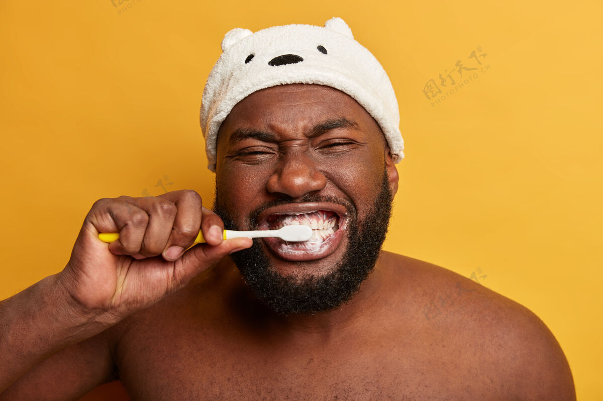 设备特写的黑人非洲男人的画像刷牙 每天早上都有例行公事牙膏微笑说话