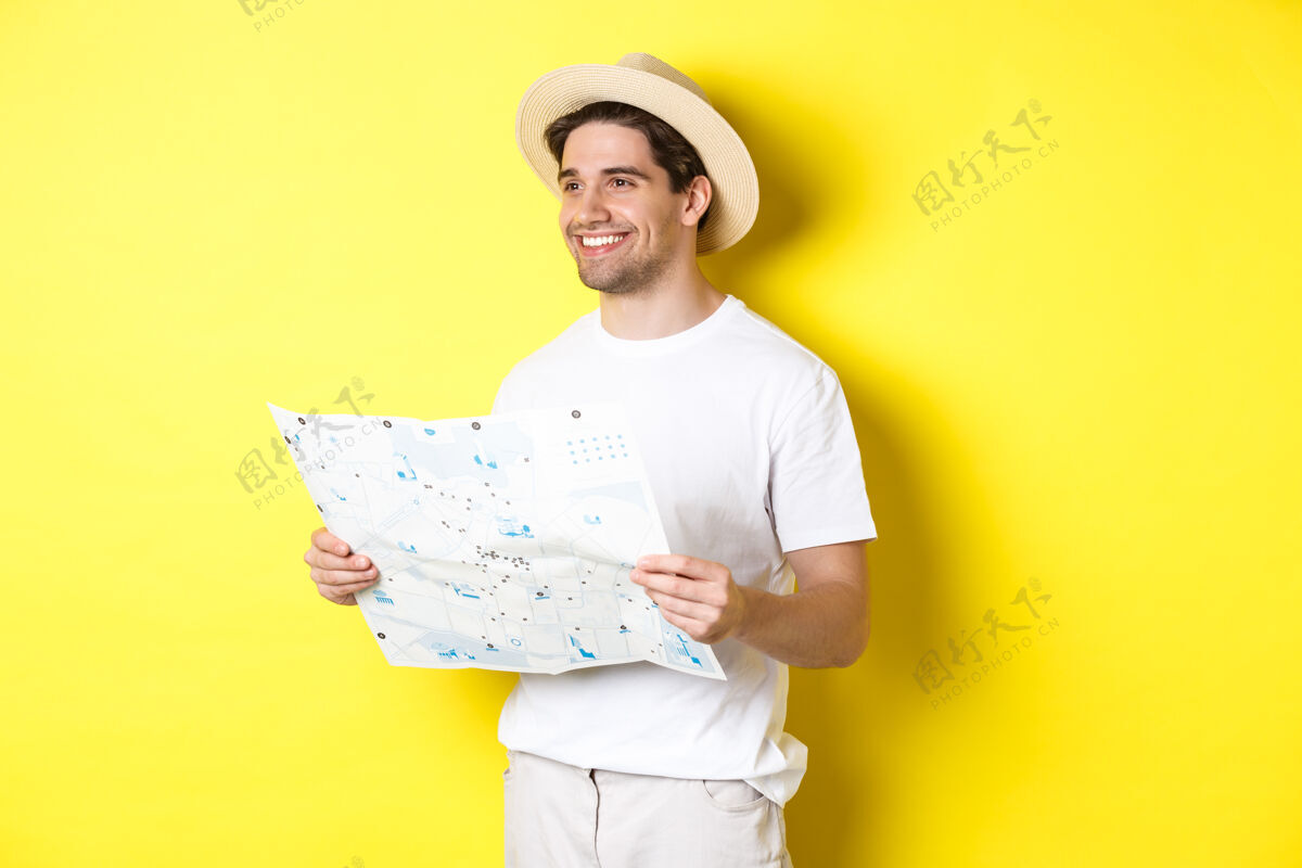 假日旅游 度假 旅游理念帅哥游客去观光 拿着地图微笑 站在黄色的背景上站立男孩帅气