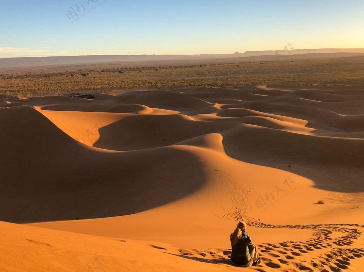 炎热坐在被铁轨包围的沙漠沙丘上的男人阳光干燥轨道