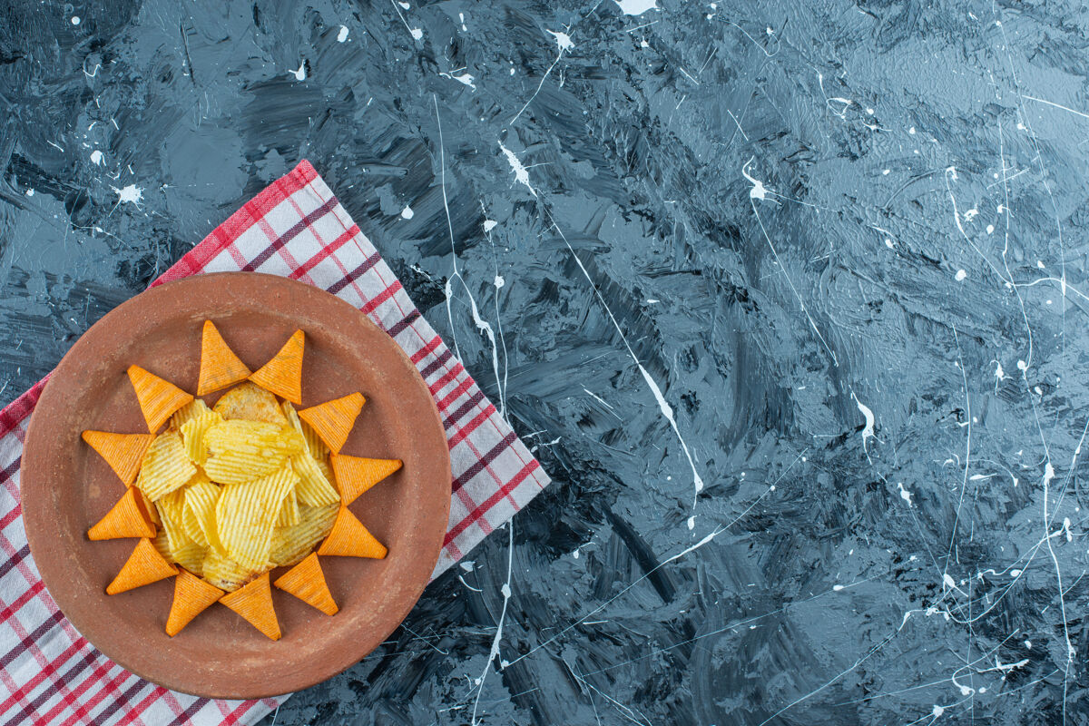烤奶酪片和圆锥形片放在一个盘子里 放在茶巾上 放在大理石背景上奶酪盐堆