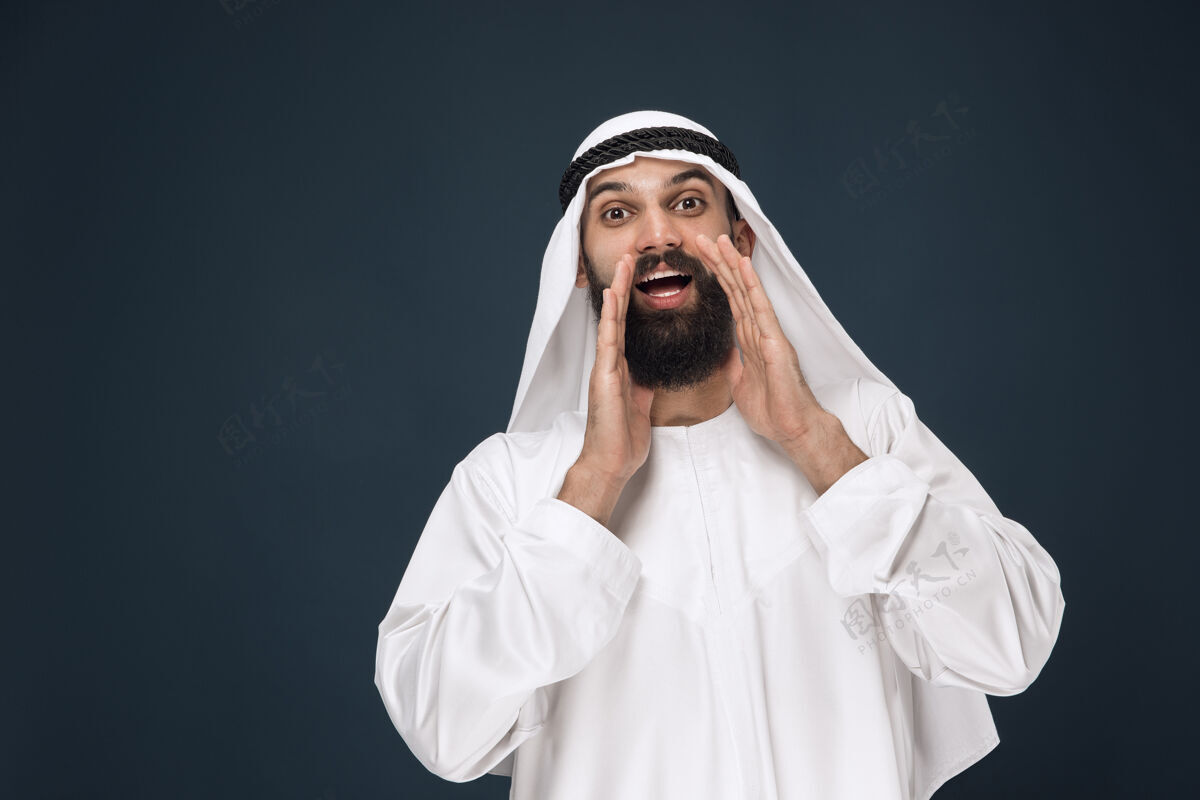 表情深蓝色工作室墙上的阿拉伯沙特商人肖像男人发呆微笑
