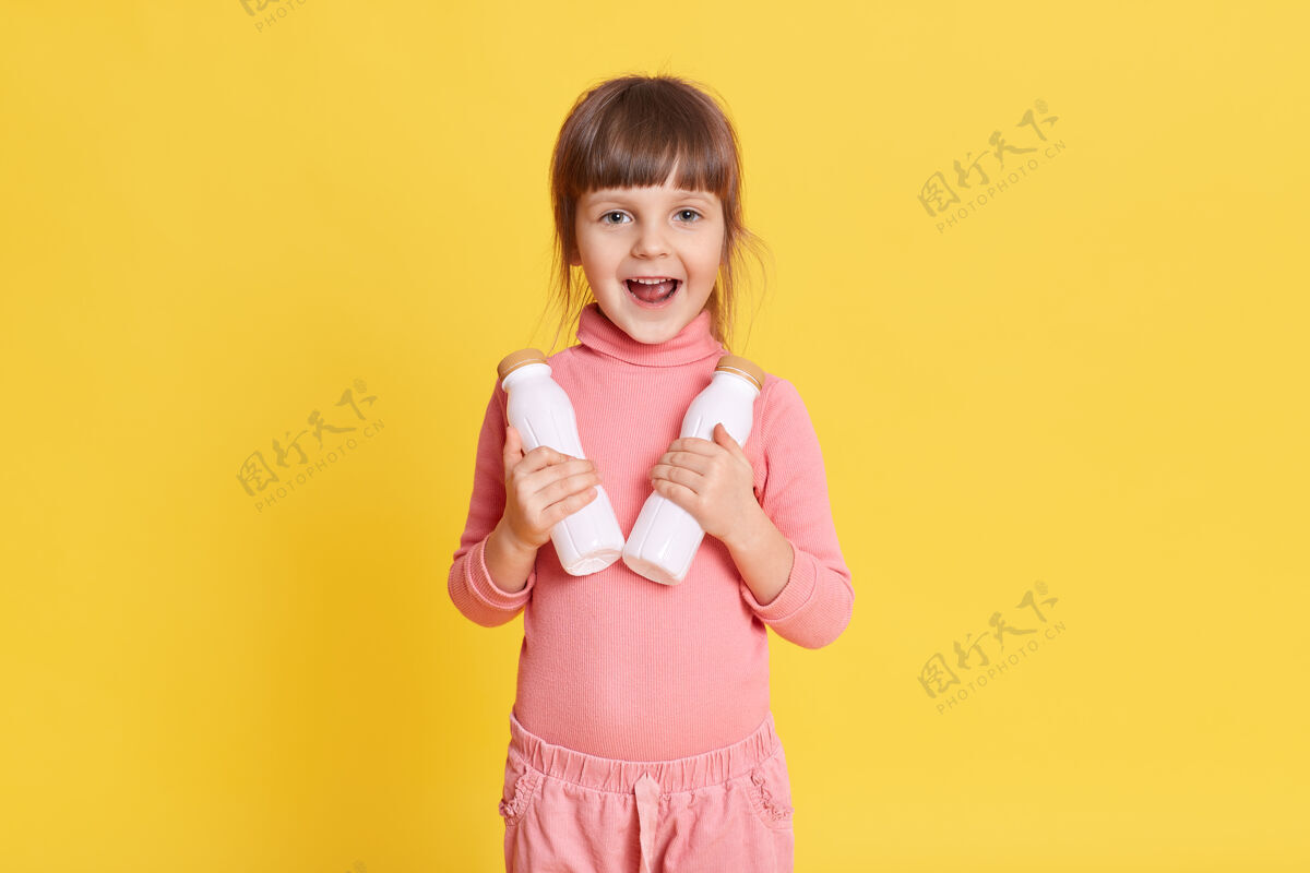 女儿穿着粉红色衣服 棕色头发 手里拿着两瓶牛奶的小美女小女孩衣服女性