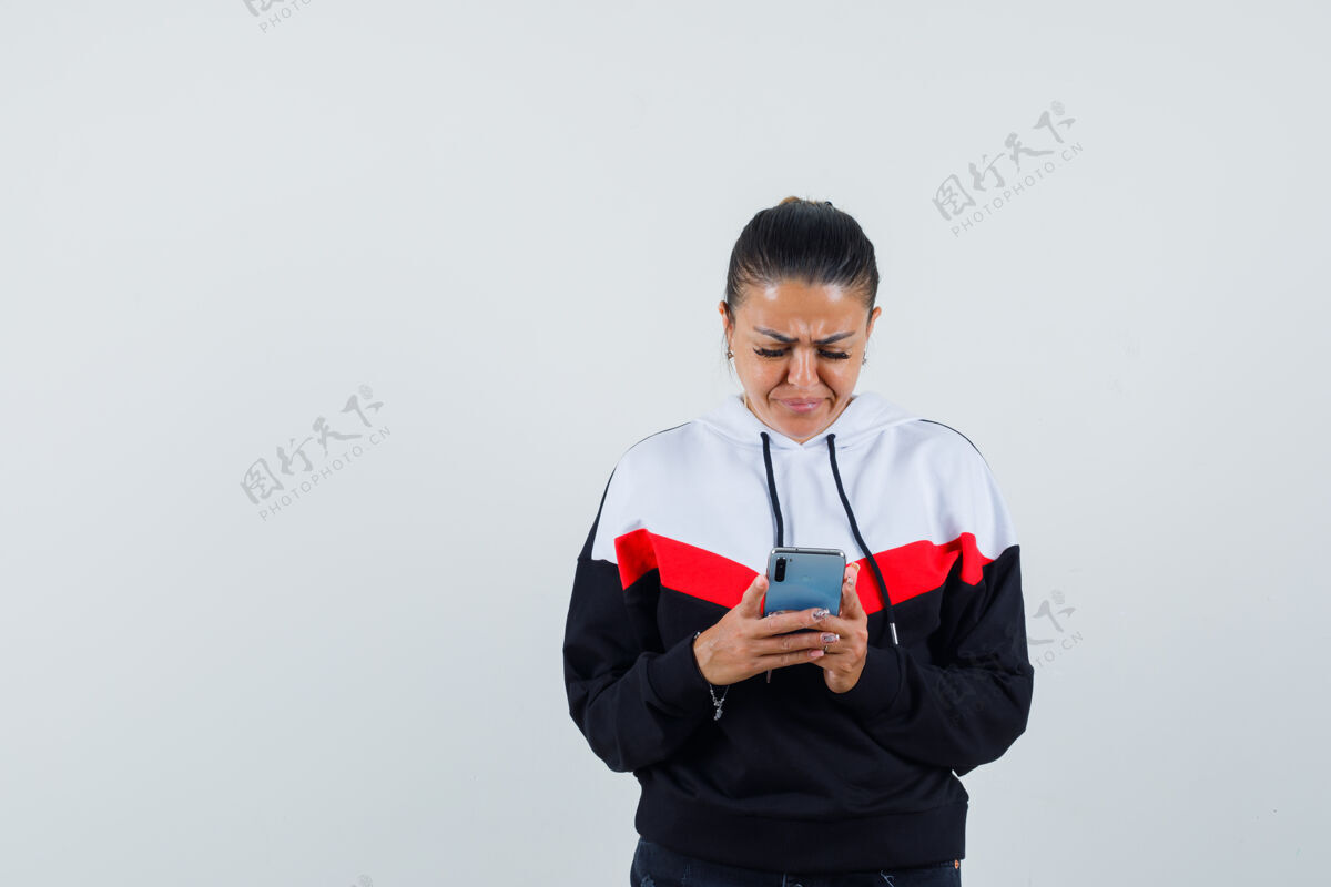 肖像身着五颜六色运动衫的年轻女性看着手机 神情哀伤 前视图电话头发正面