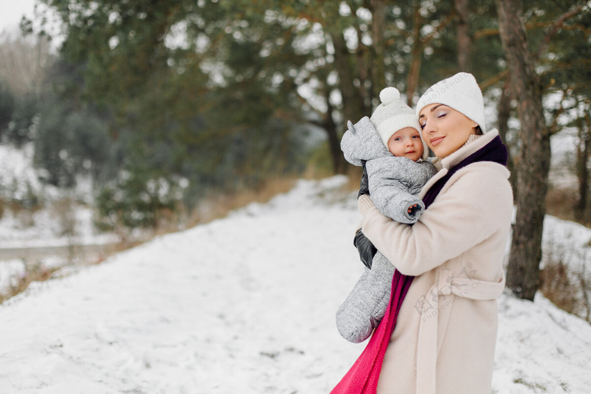 关系在一个阳光明媚的日子里 一家人在雪中散步 在冬季公园里玩得开心 互相拥抱 面带微笑乐趣休闲小