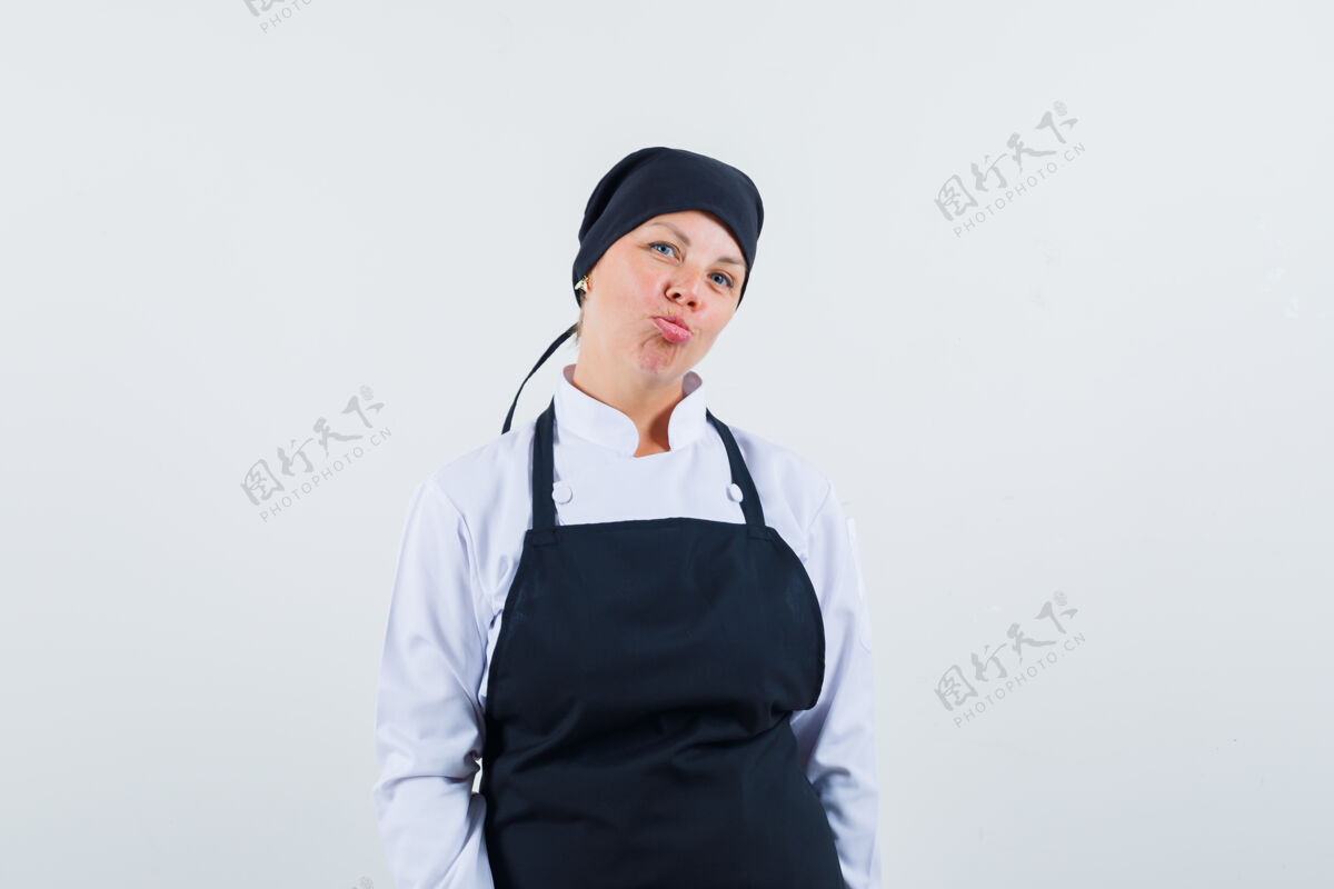 曲线金发碧眼的女人 笔直地站着 弯曲的嘴唇 穿着黑色的厨师制服站在前面 看起来很漂亮肖像化妆直