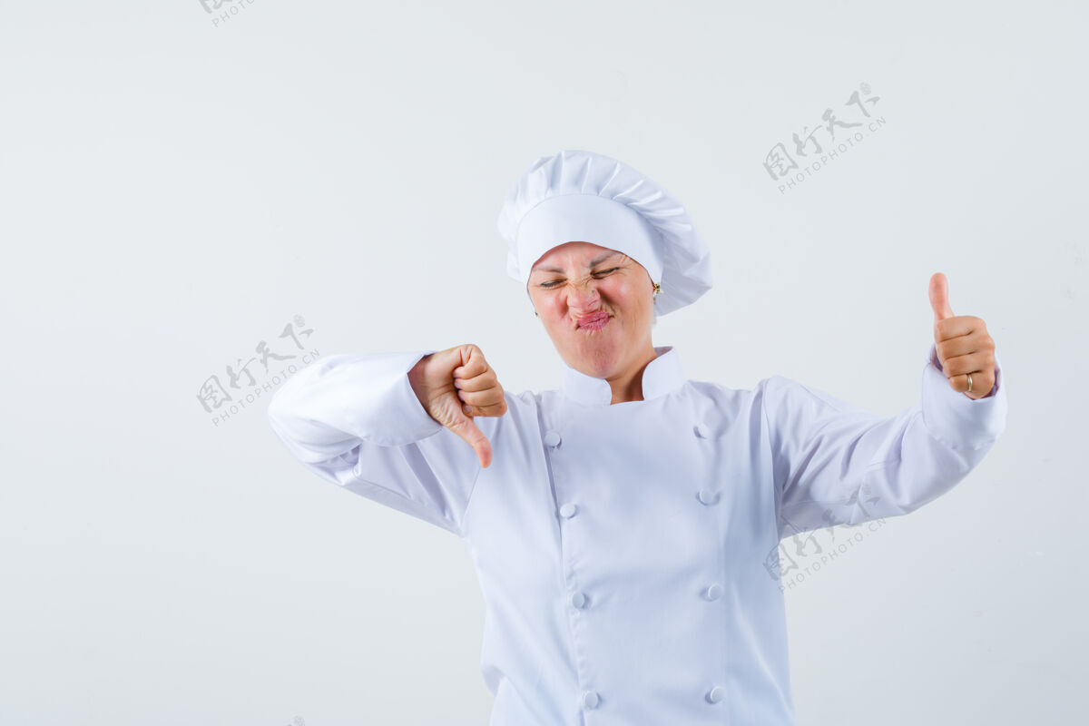 看穿着白色制服的女厨师上下摆着大拇指 神情犹豫不决时尚女士可爱