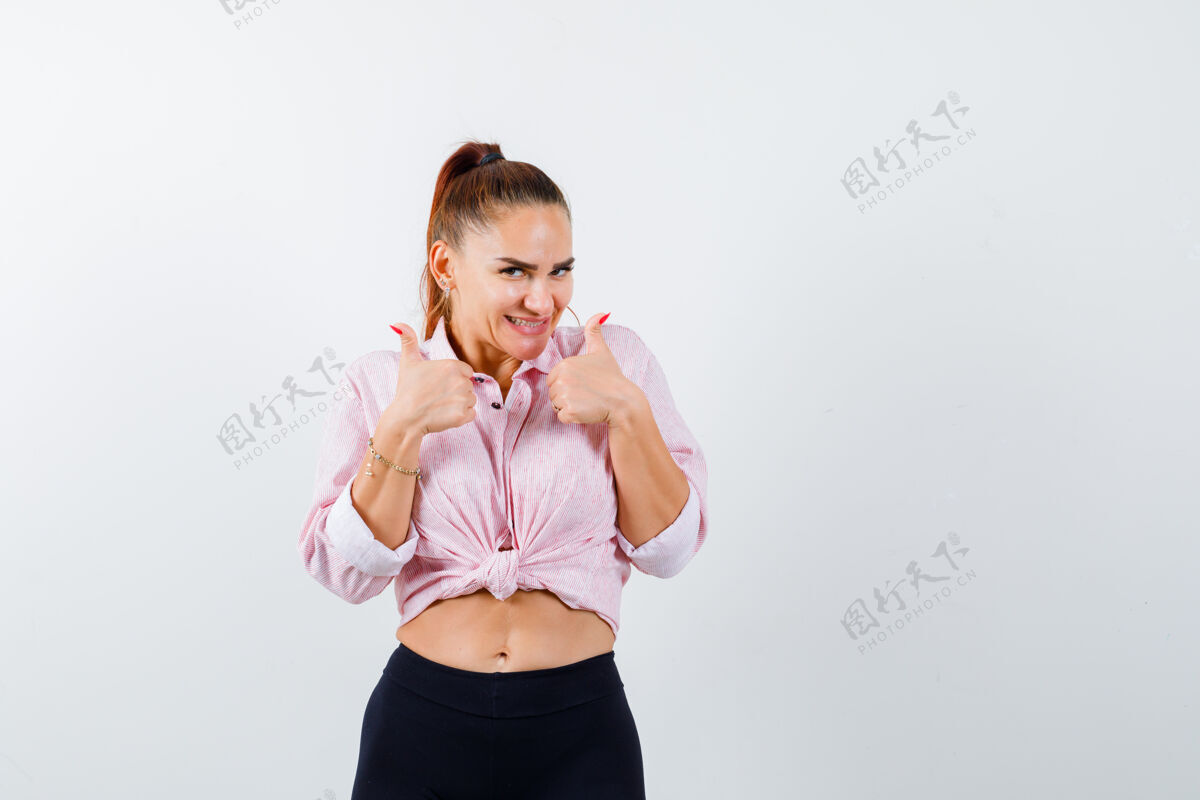 清洁年轻女性在休闲衬衫 裤子上竖起大拇指 看起来很开心 前视图衬衫健康拇指