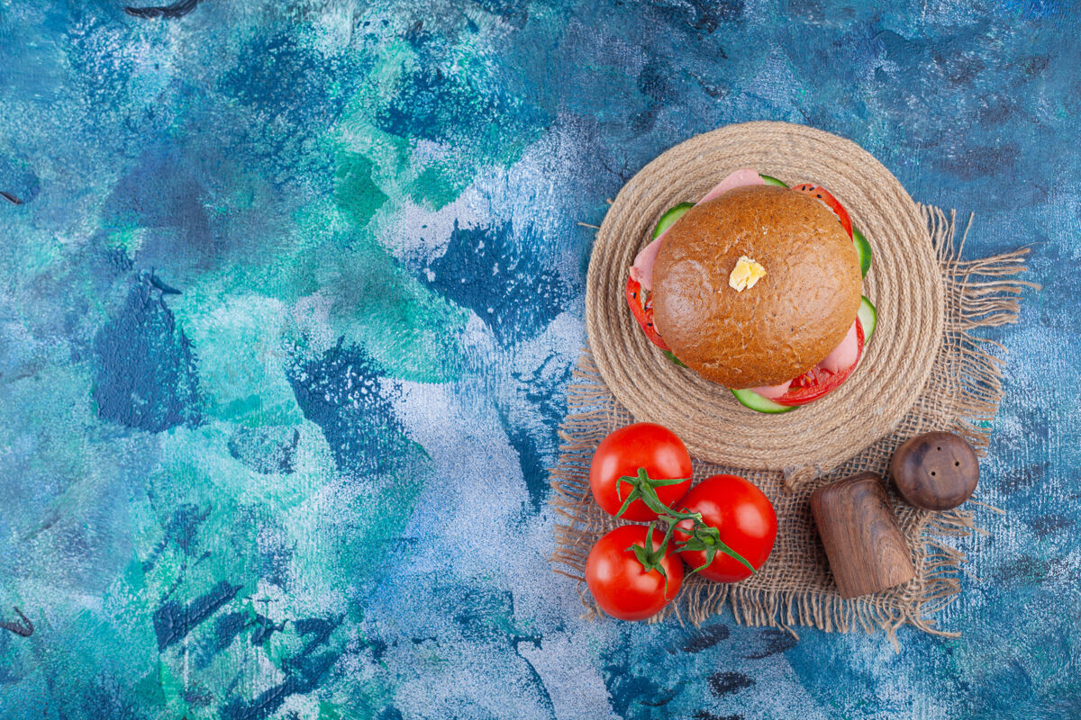 食品美味的自制汉堡包 蓝色表面有新鲜西红柿小吃顶视图面包
