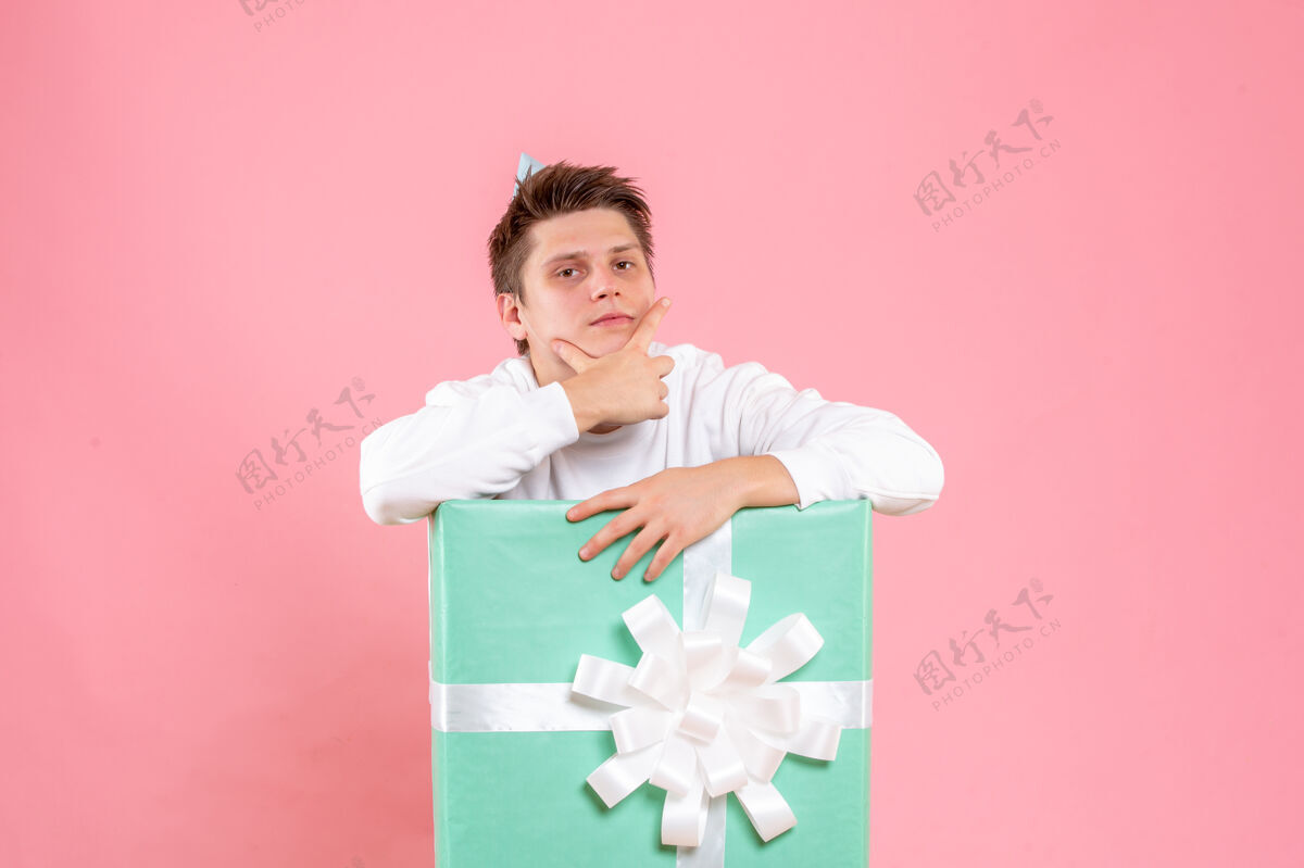 圣诞正面图：年轻男性 身穿白色衬衫 头戴帽子 背景为粉色年轻男性白色粉色