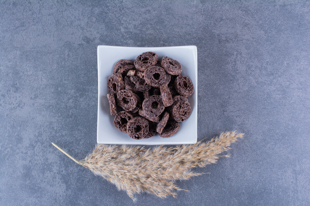 可可健康早餐 巧克力玉米圈放在石头盘子里小环巧克力甜食