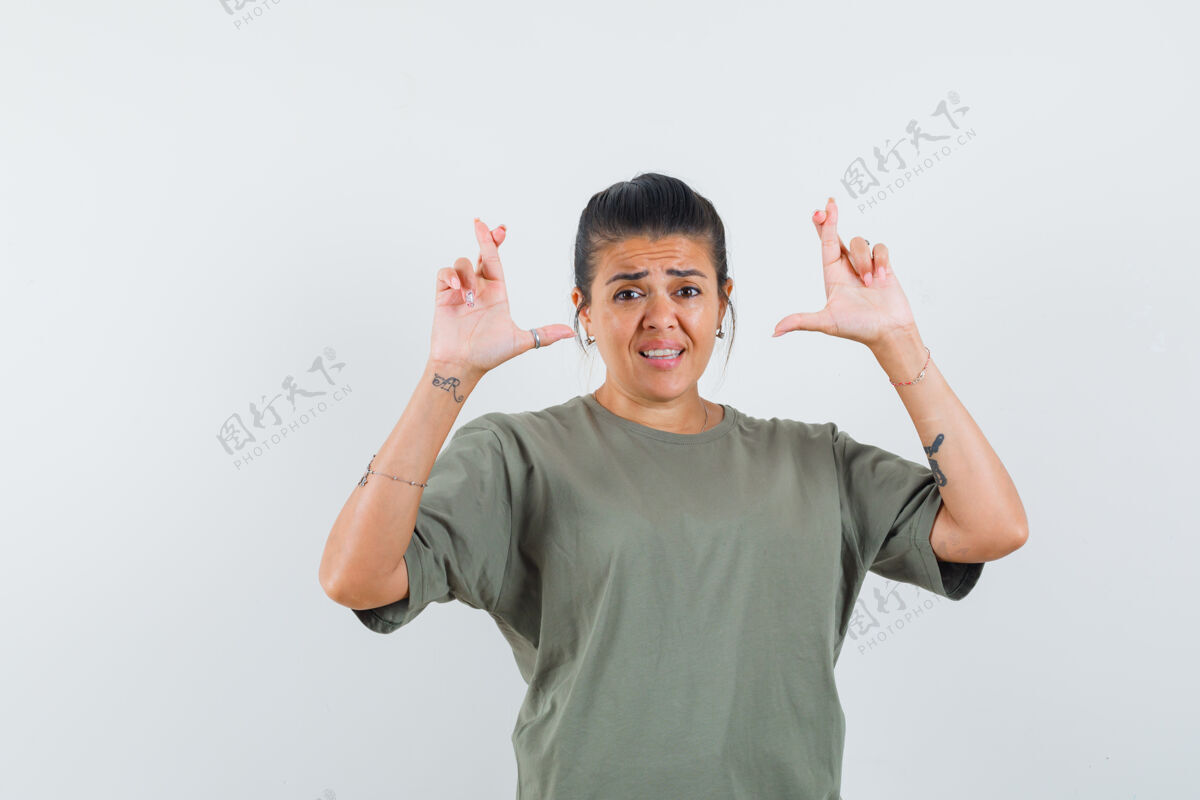 欢呼一个穿着t恤 手指交叉的女人 看起来很梦幻肖像女性护理