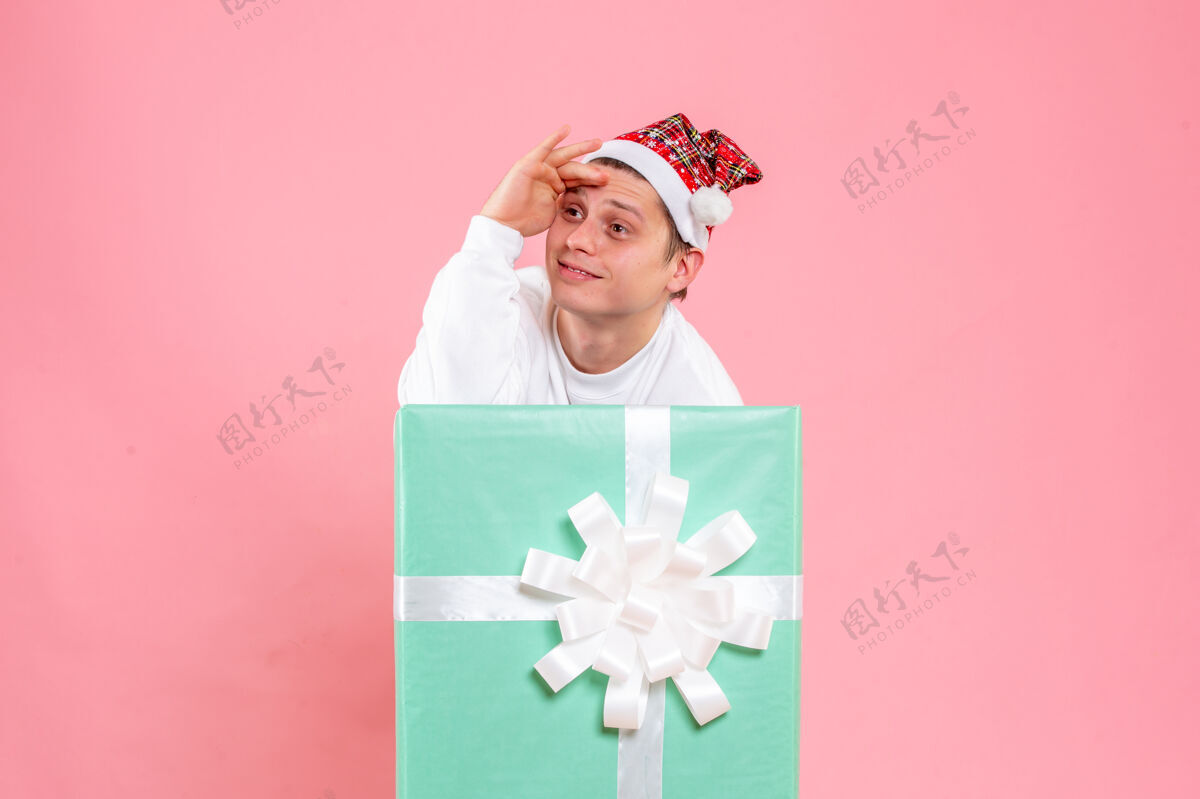 礼物正面图：穿着白色衬衫的年轻男性 粉色背景的礼物正面白色丝带