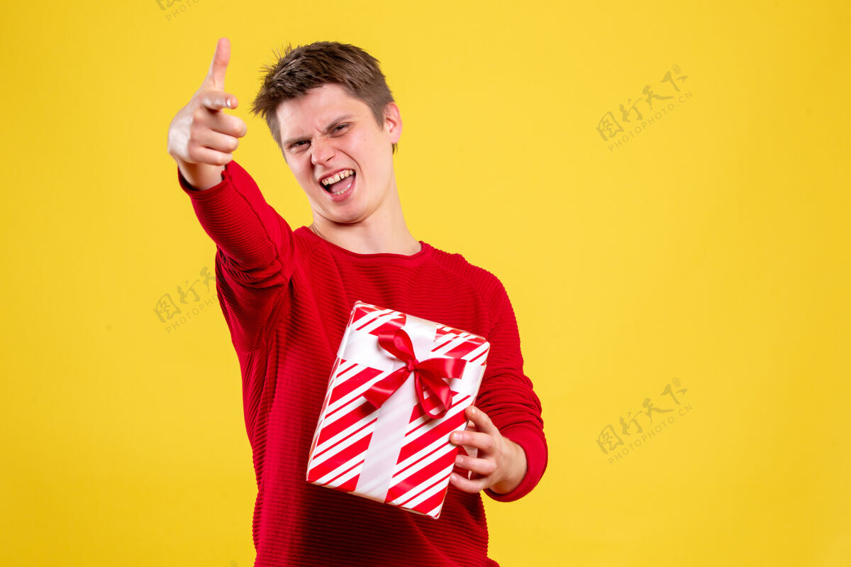 风景前视图黄色背景上的年轻男性圣诞礼物礼物年轻男性情感