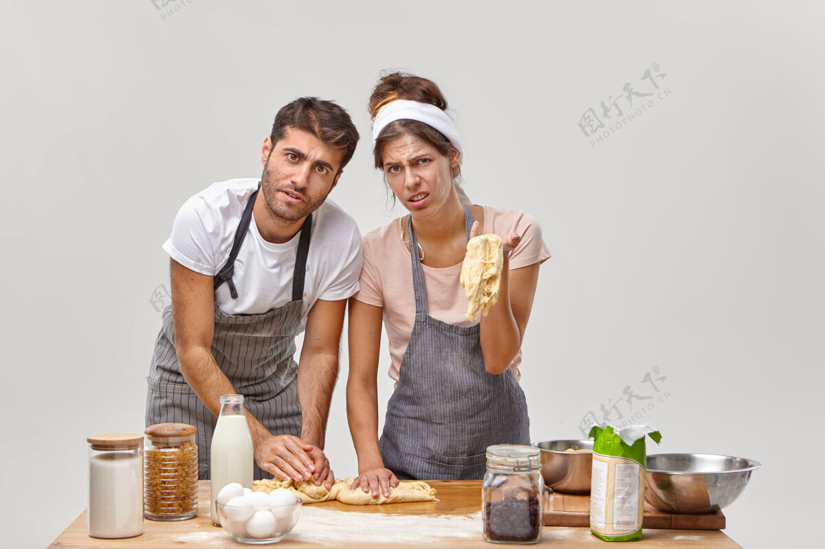 制作夫妻俩在厨房摆姿势准备美味的晚餐配料丈夫面包师