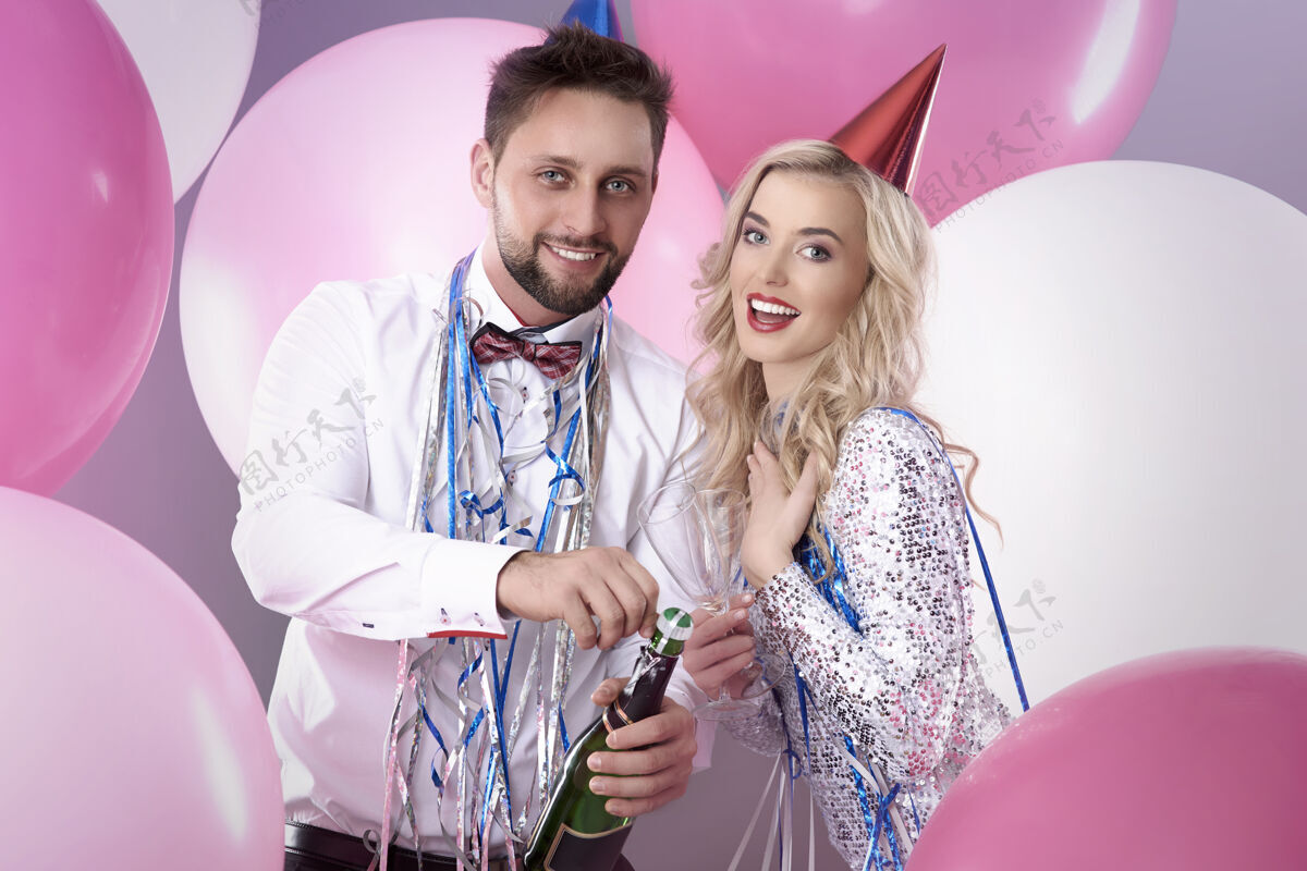 庆祝一对年轻夫妇在庆祝新年前夜拥抱发光酒精