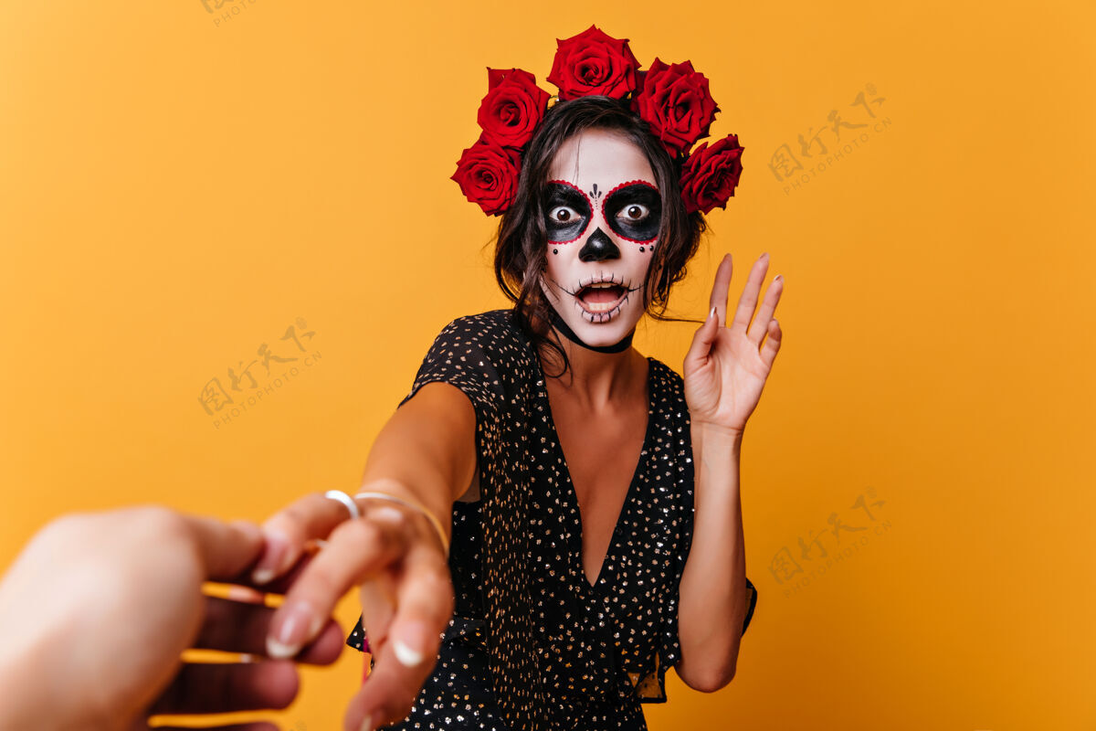女性震惊的墨西哥僵尸在黄色背景下摆出有趣的姿势灵感来自穿着万圣节服装的女模特 表达着惊奇脸女孩黑发