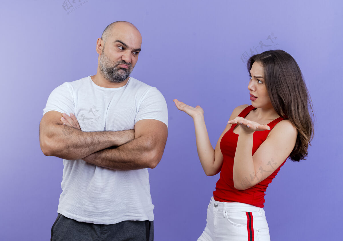 每个愤怒的成年夫妇互相争吵皱眉的男人站在那里 紧闭的姿势 不高兴的女人两手空空的手情侣男人