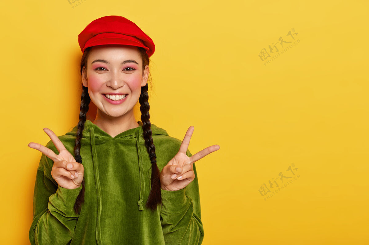 衣服笑容可掬的亚洲少女双手露出和平姿态 笑容灿烂女人表情韩语