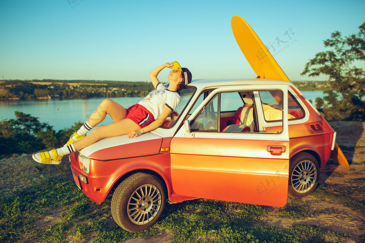 年轻在河边的一个夏日里 一个女人坐在沙滩上的汽车上休息放松自然女人