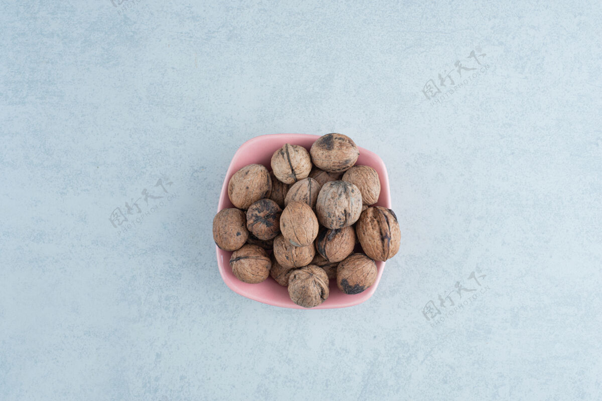 食物在大理石背景上放满坚果的粉红色小盘高质量照片盘子大理石美味