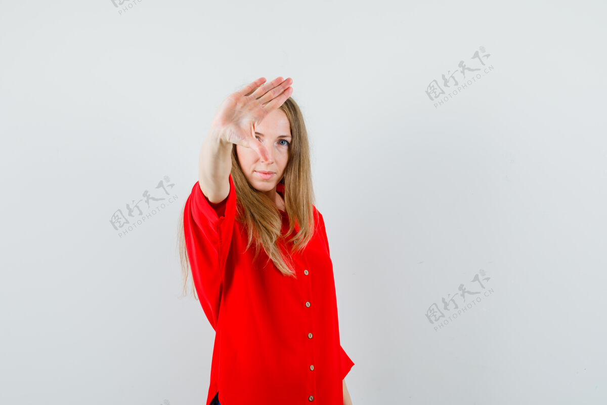 停止一个穿红衬衫的金发女人 做了个停车的手势 看起来很坚决 健康衬衫漂亮