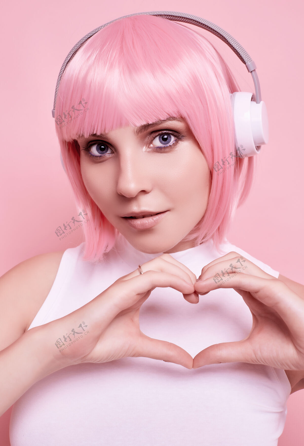 耳机粉红头发的美女肖像在耳机里欣赏音乐聚会女人无线
