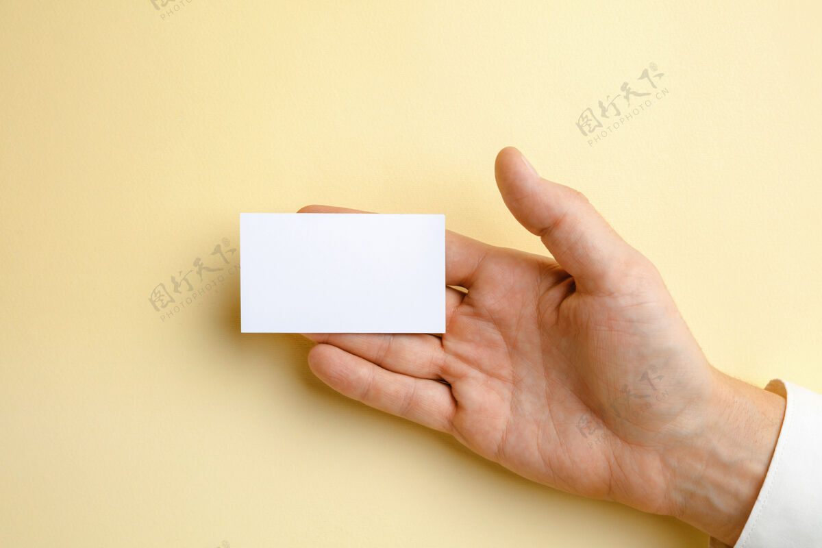 手臂男性手拿一张空白名片放在柔软的黄色墙上 用于文字或设计空白信用卡模板用于联系或在商业 金融 办公室使用复制空间问候语商务人员明亮