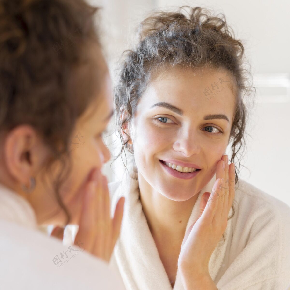 美容照镜子的时候在脸上涂面霜的女人镜子面部护理房子