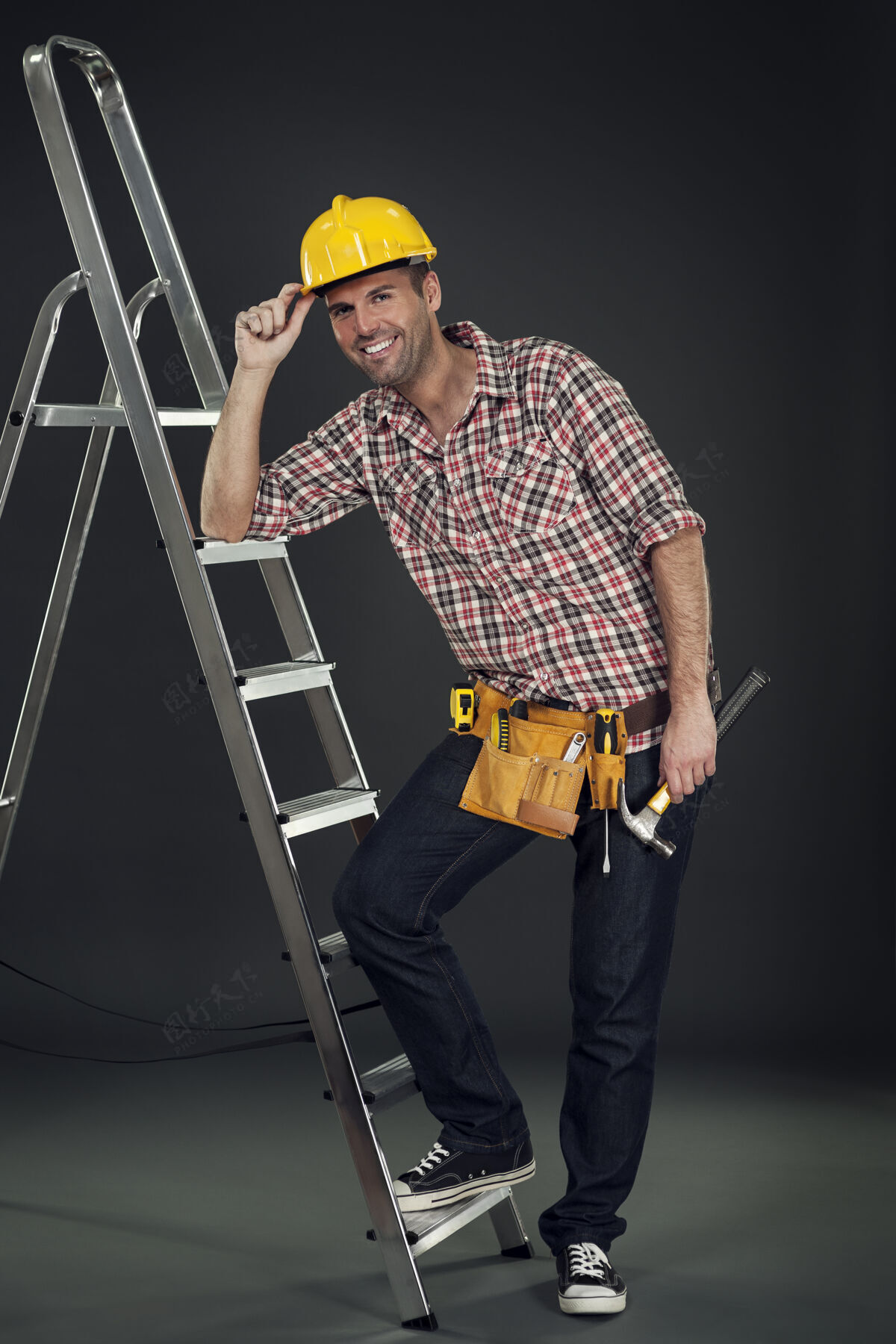 安全帽靠在梯子上的体力劳动者手持运动鞋机械师