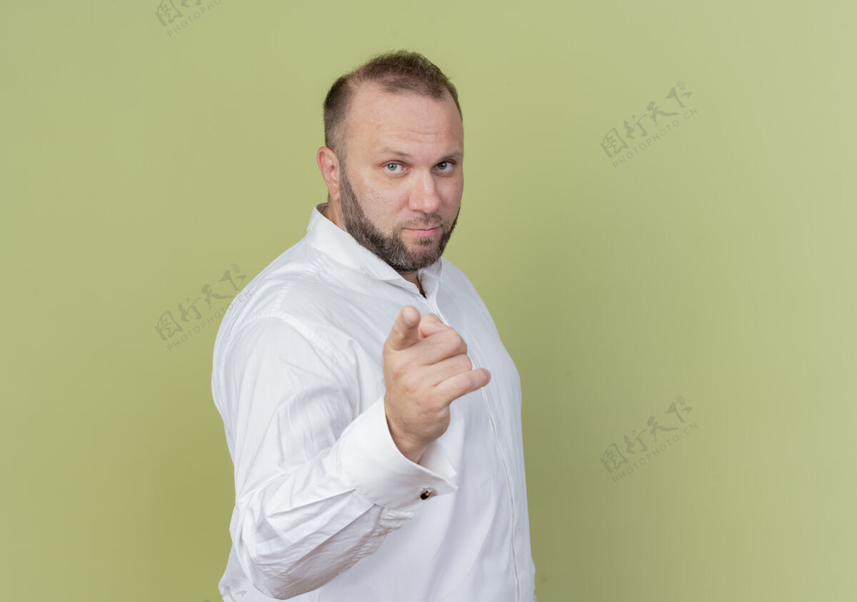 穿一个留着胡子的男人穿着白衬衫 用食指指着光墙看胡子手指
