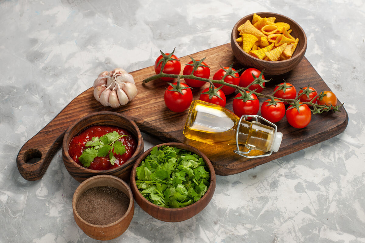 前正面图新鲜的樱桃西红柿配调味料和绿色蔬菜 白色表面蔬菜餐食品健康沙拉生的新鲜番茄