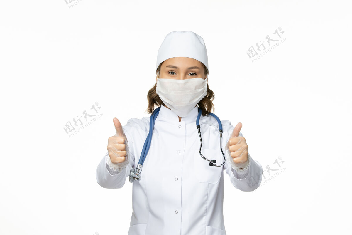 到期正面图女医生穿着白色医疗服 戴着口罩 因白色办公桌上有冠状病毒大流行病毒病隔离病毒医生专业人员冠状病毒