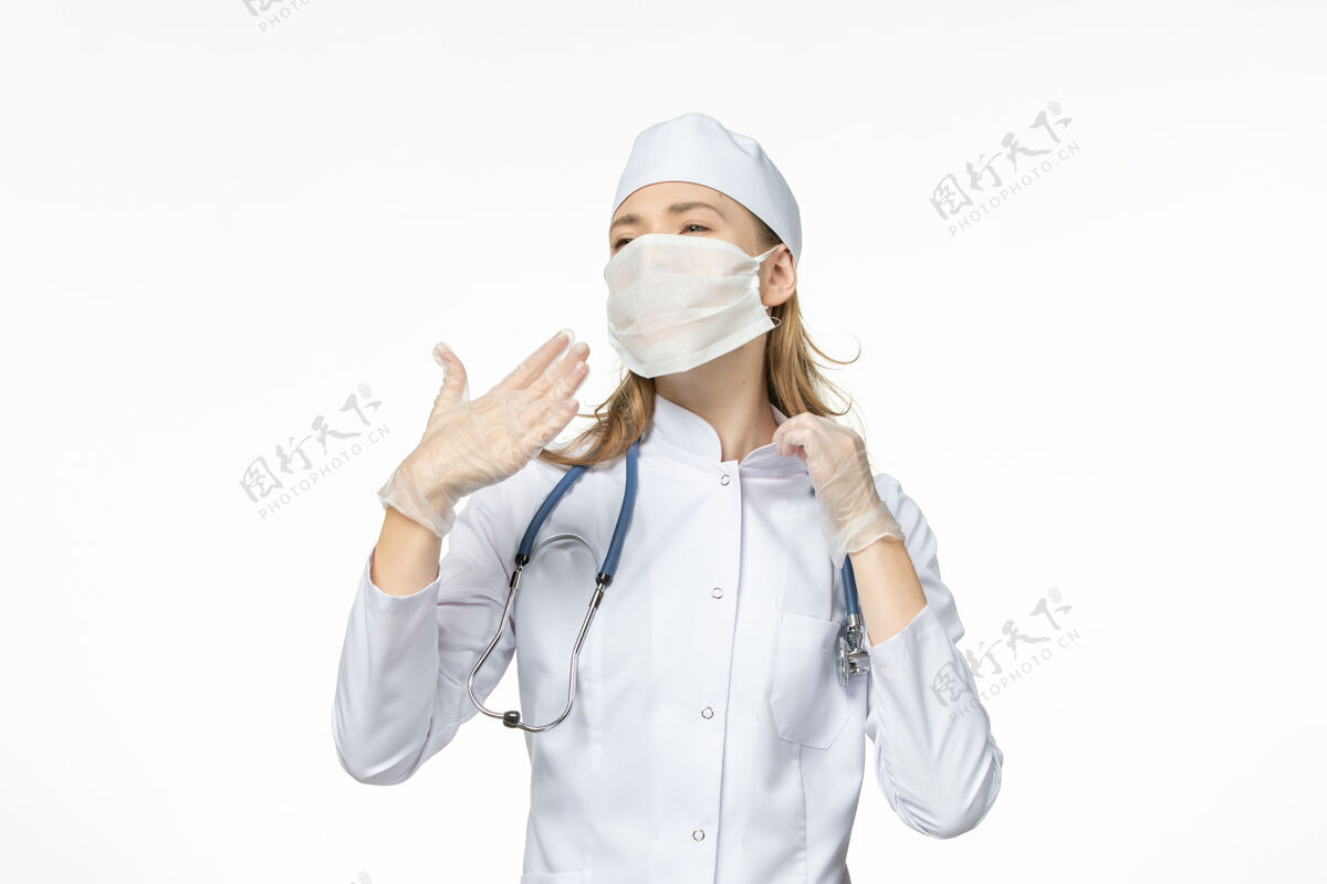 冠状病毒防护正面图：女医生穿着医疗服 戴着口罩和手套 因桌上有冠状病毒 呈浅白色 大流行性冠状病毒冠状病毒面罩医疗人员