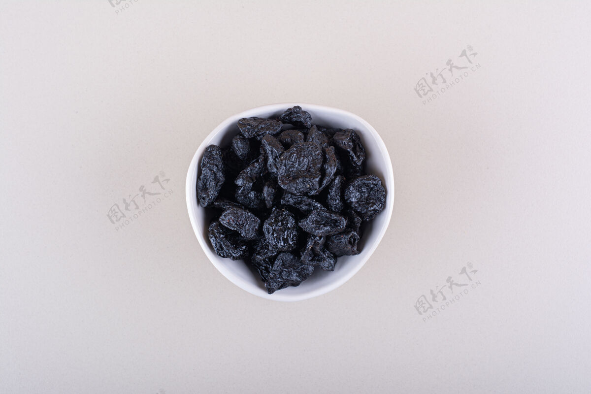 营养白色的李子干果碗放在白色的表面高品质的照片黑天然食品