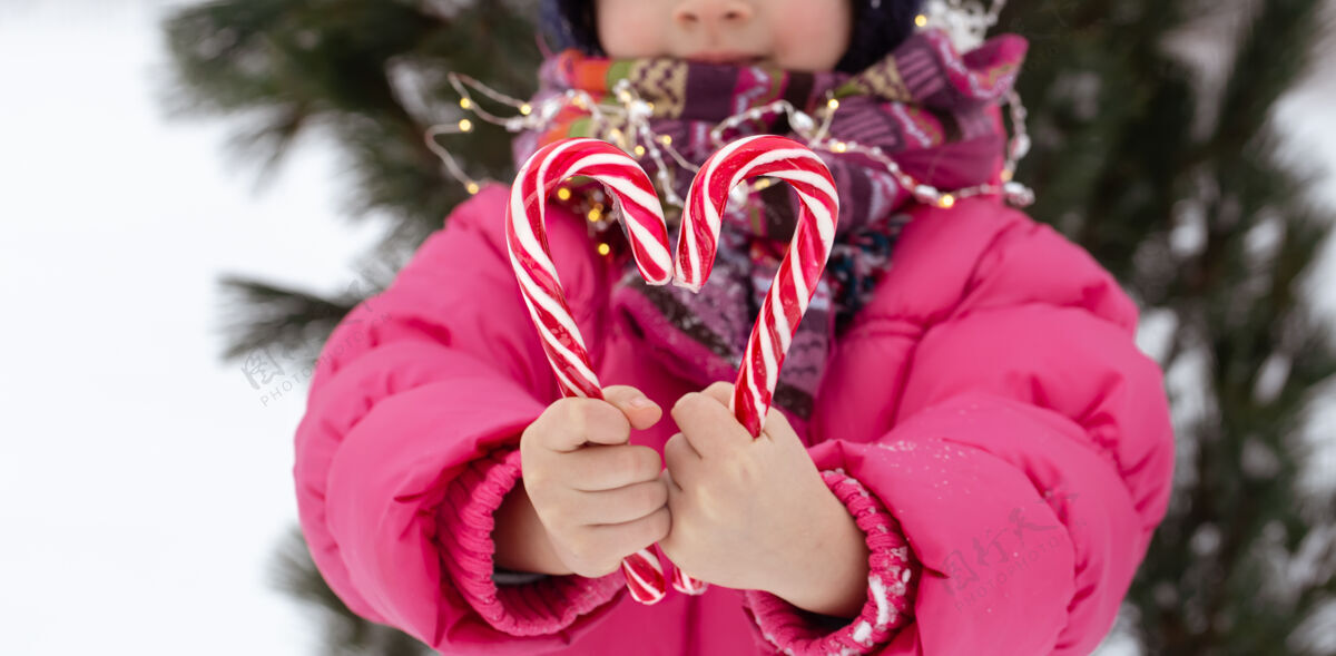 雪一个拿着大糖果棒的孩子圣诞节的概念孩子冬天圣诞节