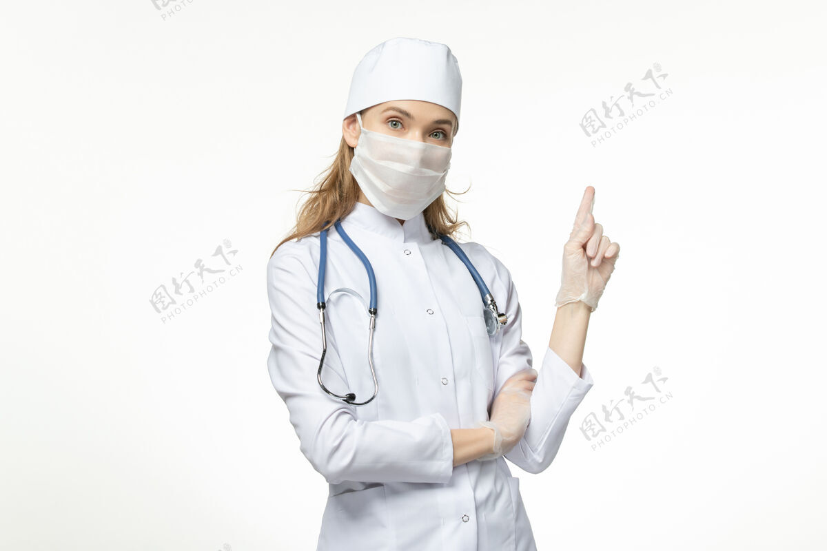 到期正面图女医生身穿白色医疗服 带无菌口罩 因白色办公桌上有冠状病毒病大流行性疾病冠状病毒-办公桌女性冠状病毒预防