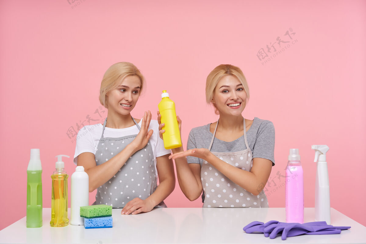 洗涤剂年轻的金发可爱的主妇们戴着橡胶手套准备春季大扫除困惑不高兴年轻