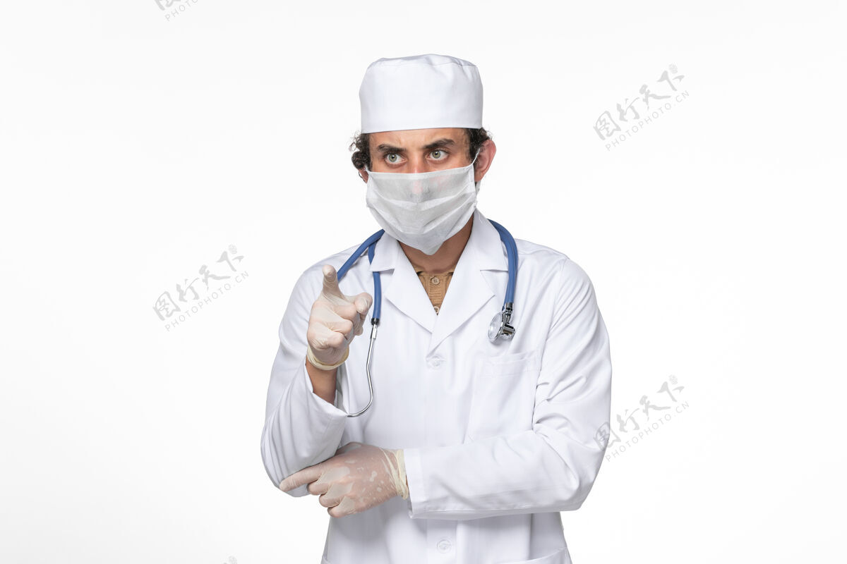 防护正面图：男医生穿着医疗服 戴着口罩 以防白墙病毒溅起冠状病毒大流行医生套装视图