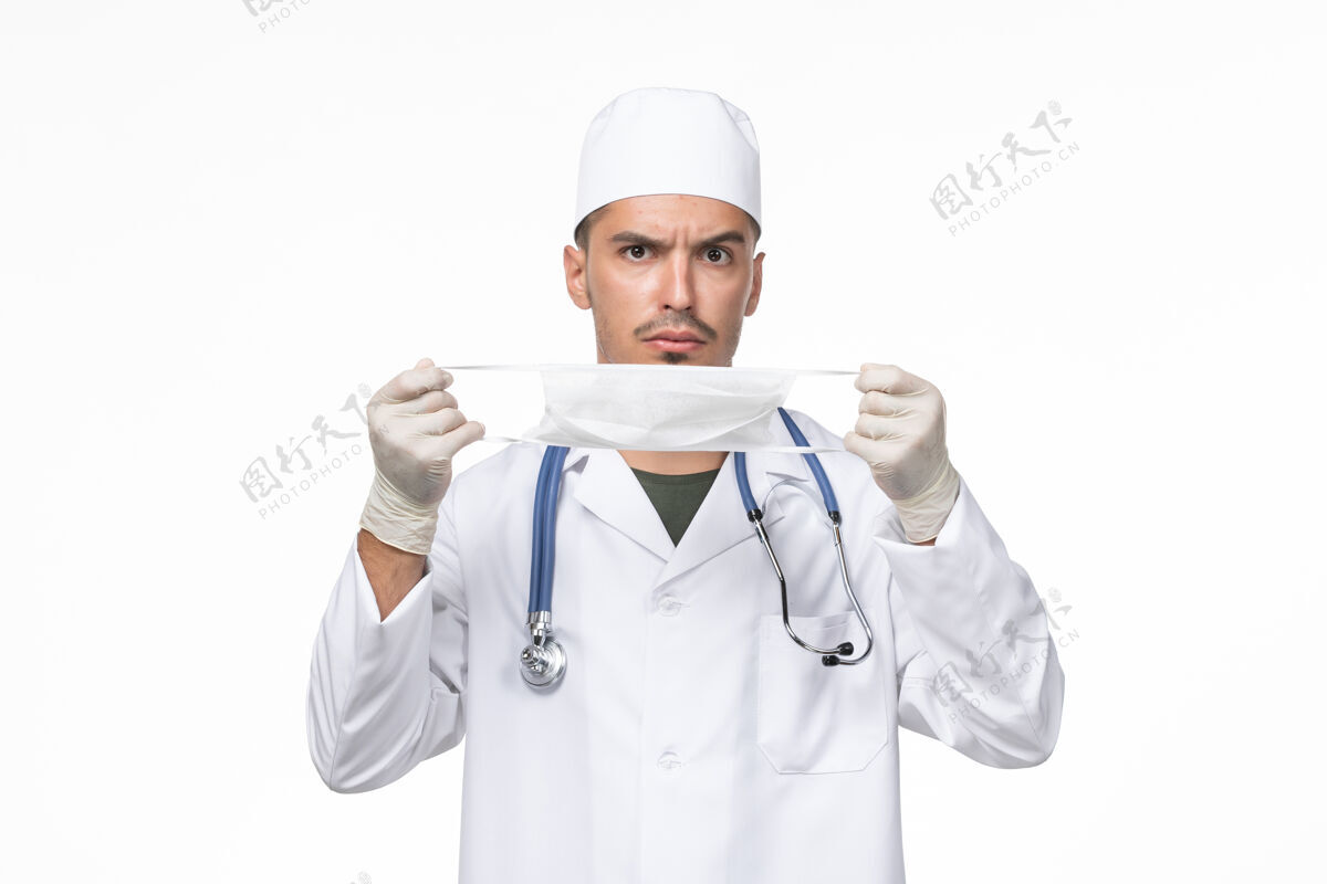 男性正面图：男医生穿着医疗服 戴着防冠状病毒口罩 白墙病毒-疾病大流行疾病正面西装