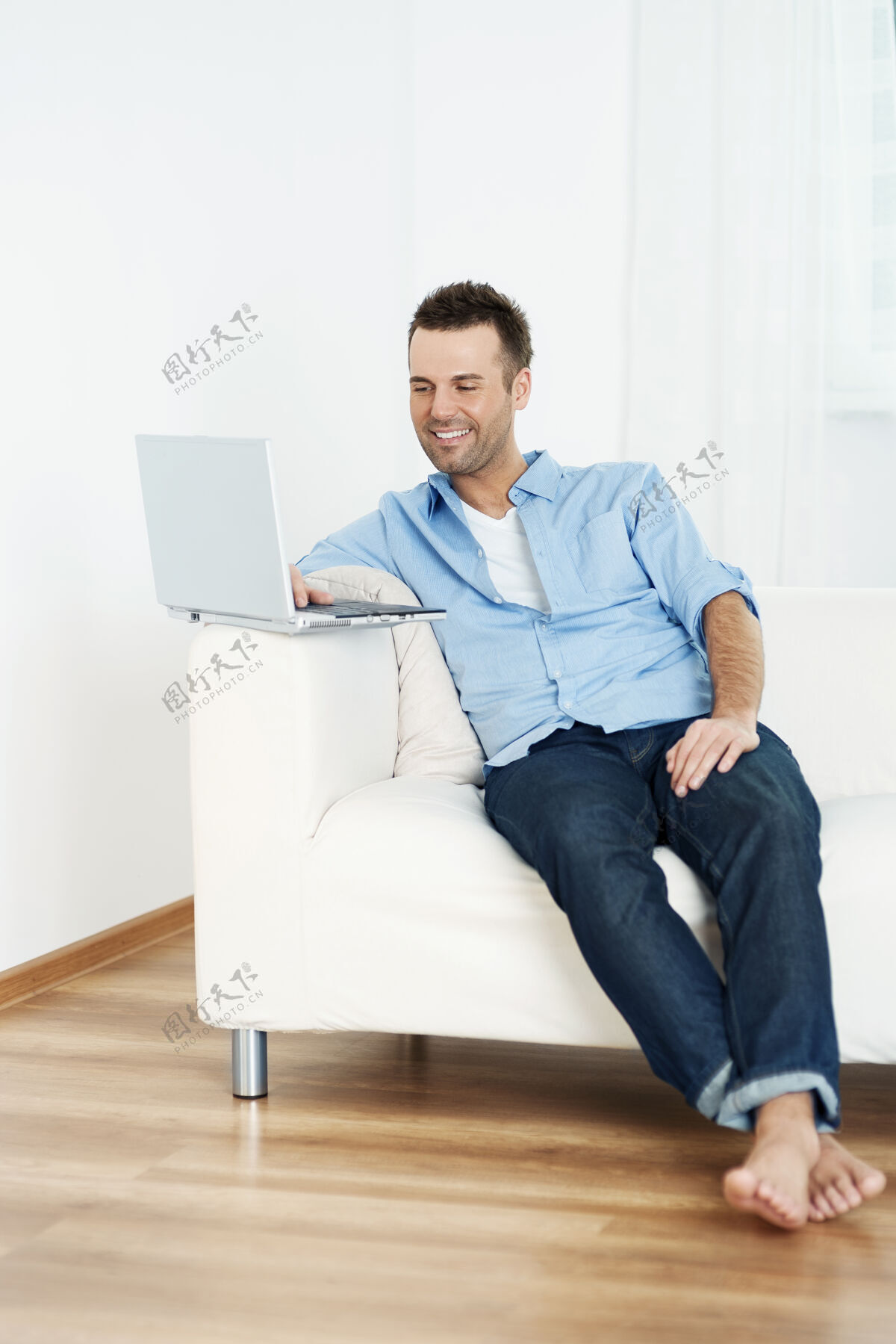 白色在家里用笔记本电脑的男人牙齿微笑电脑瘦