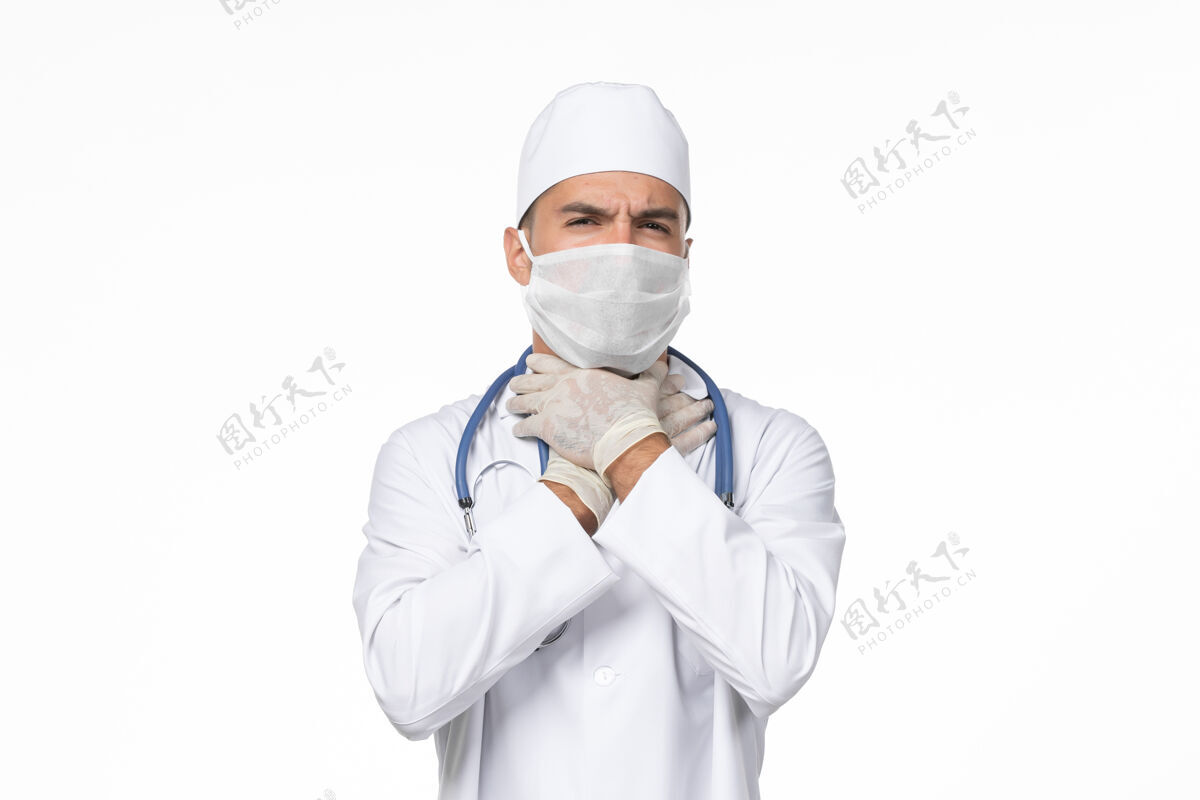医疗正面图：男医生穿着医疗服 戴着口罩 因为白色办公桌上的柯维德-大流行病毒病男人男性外套