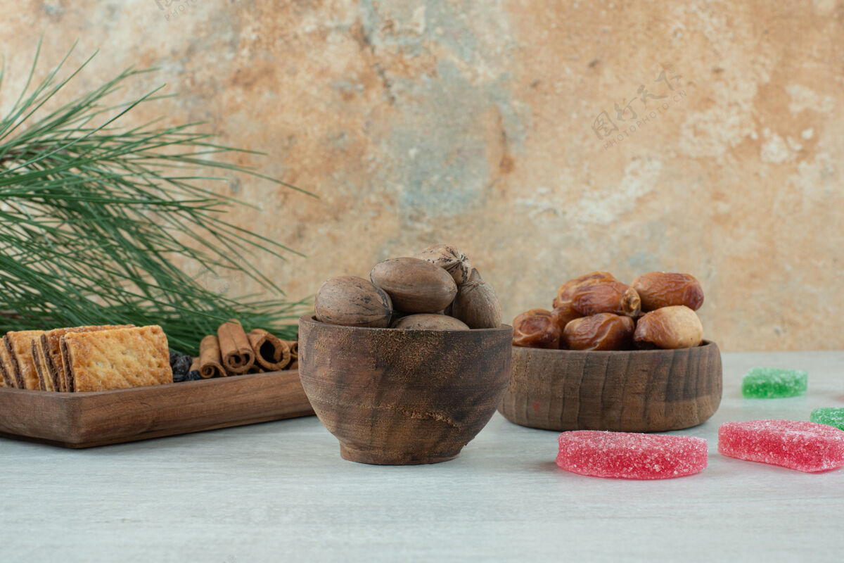 葡萄干两个木制碗 白色背景上有干果和坚果高品质照片肉桂木头碗