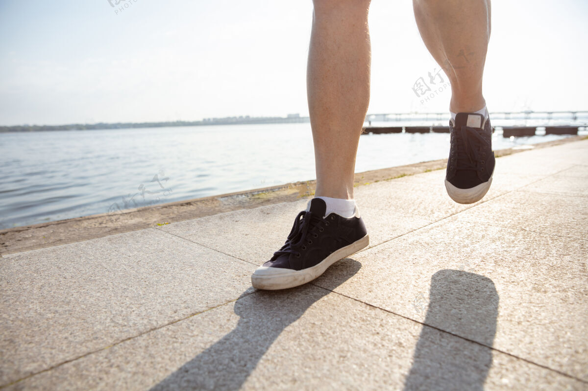 健康高级男子作为跑步者袖标或健身跟踪器在河边训练森林老年人