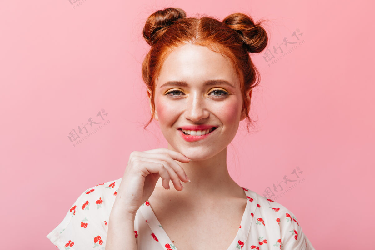 女人调皮的红发女士 浓妆艳抹 在粉色背景上眨眼微笑衬衫美丽白色t恤