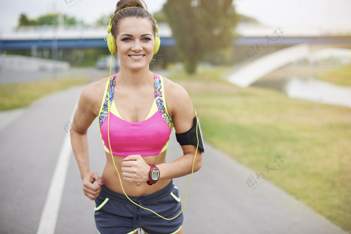 微笑年轻女子在户外运动好天气去河边慢跑爱好锻炼运动器材